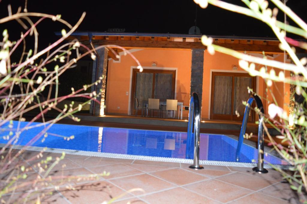 a swimming pool in front of a house at Villa Artemia in Manerba del Garda