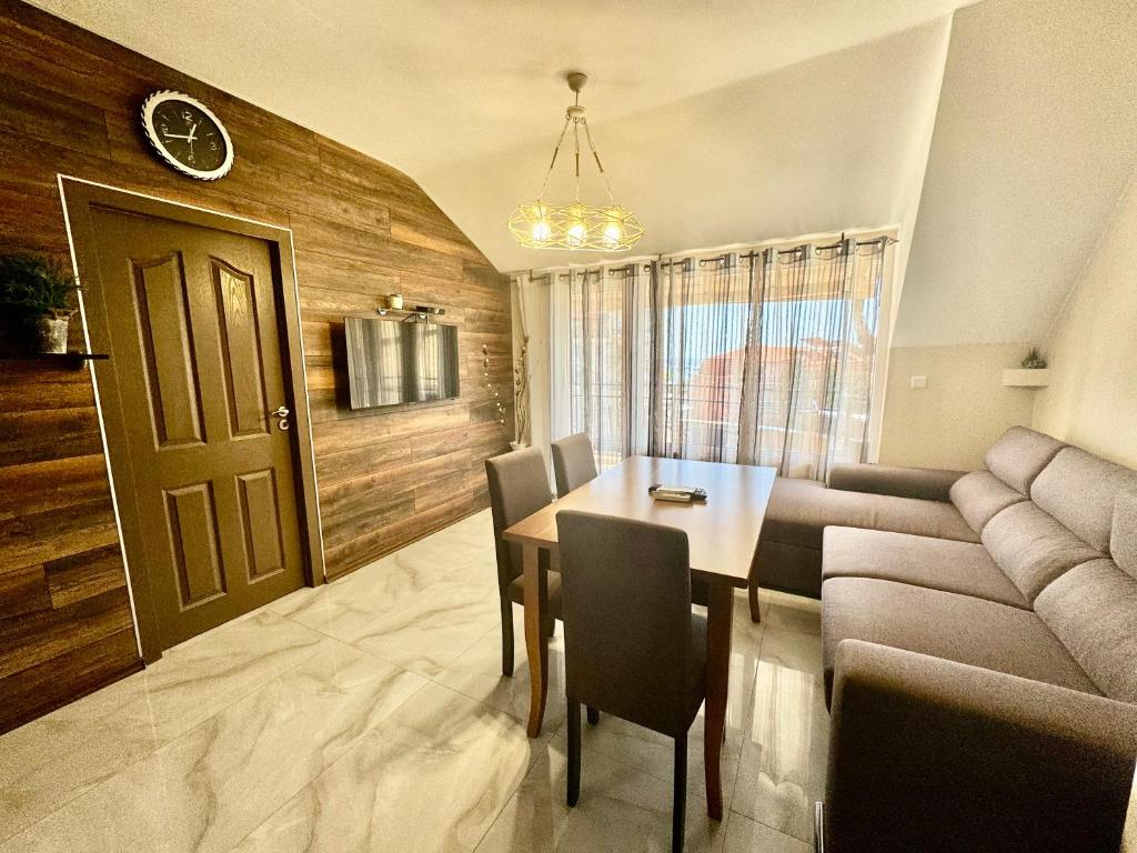 a dining room with a table and a couch at Апартамент Свети Влас in Sveti Vlas