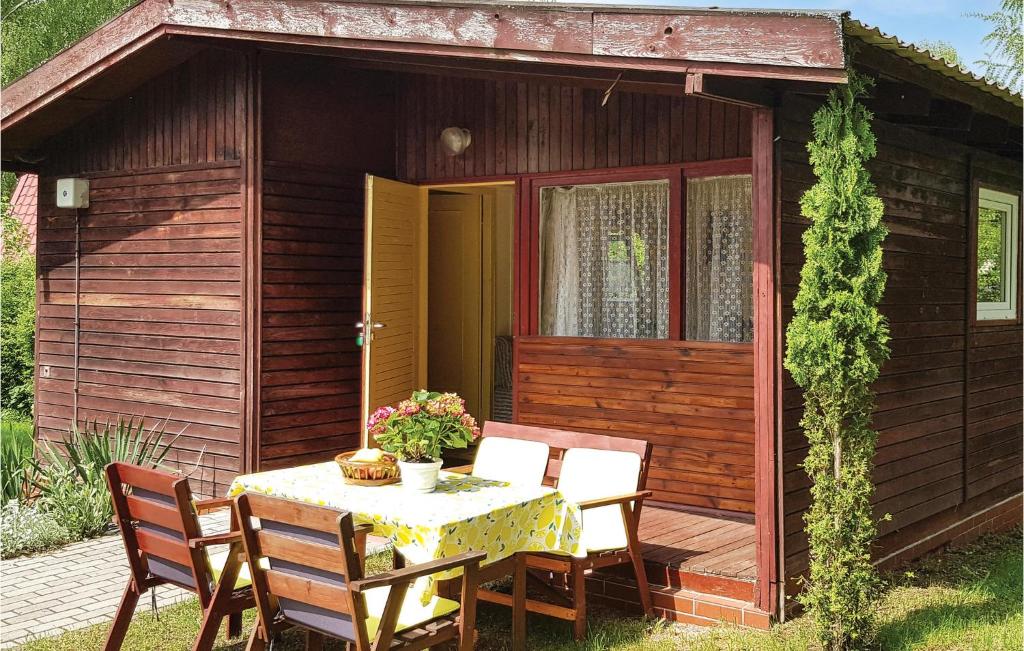 a table and chairs in front of a small cabin at Holiday Home Morag Kretowiny Iv in Pojezierce
