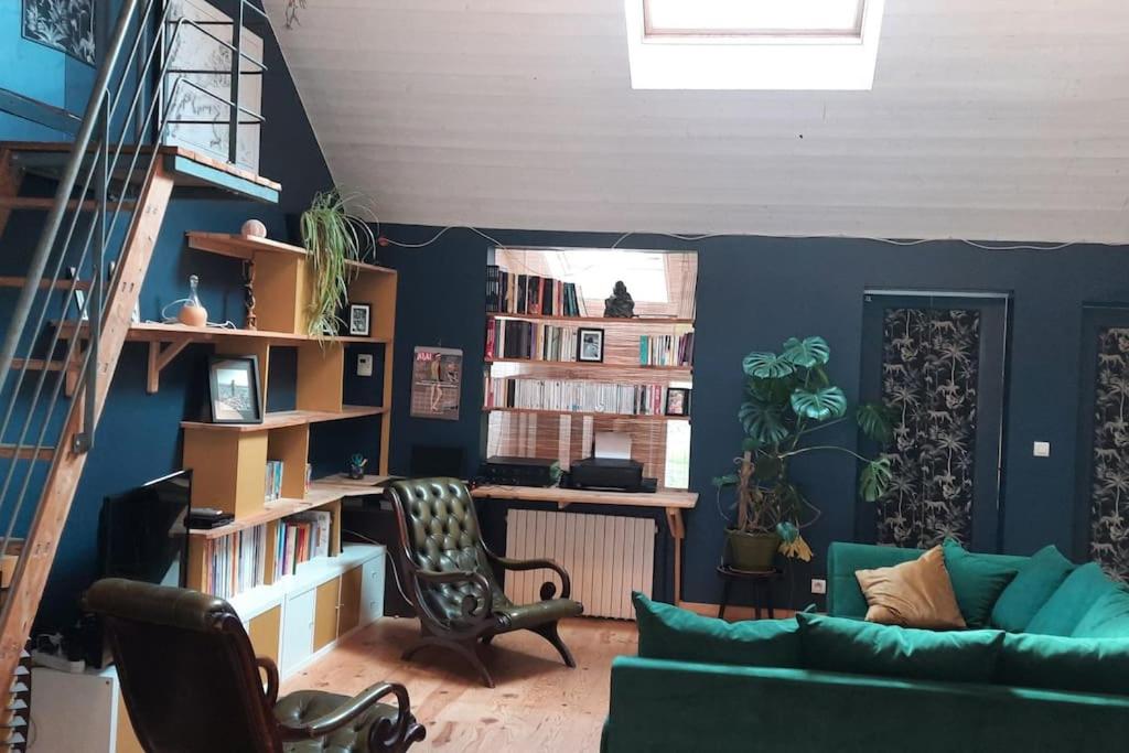 - un salon avec un canapé vert et une étagère dans l'établissement Maison entre mer et campagne, à Plouha