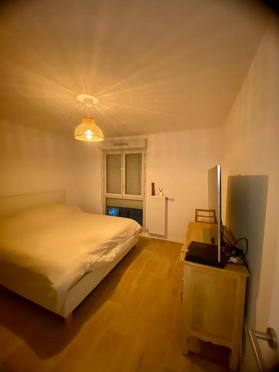 - une chambre avec un grand lit et une lumière dans l'établissement Super logement à voir, à Sevran