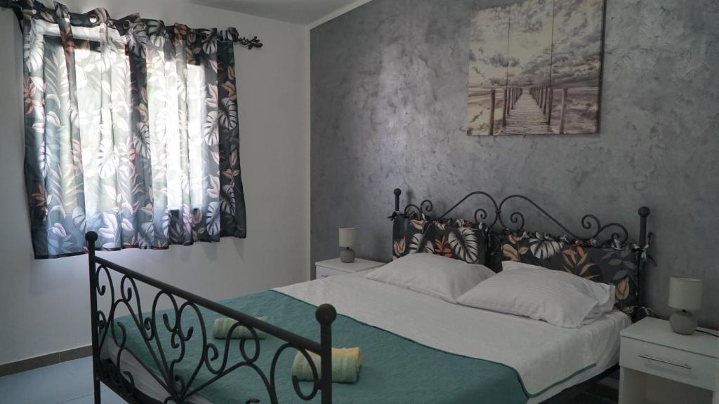 a bedroom with a bed with a wrought iron headboard at Apartments Pines in Bar