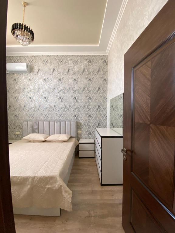 a bedroom with a bed and a dresser and a door at Apartment Atina in Kutaisi