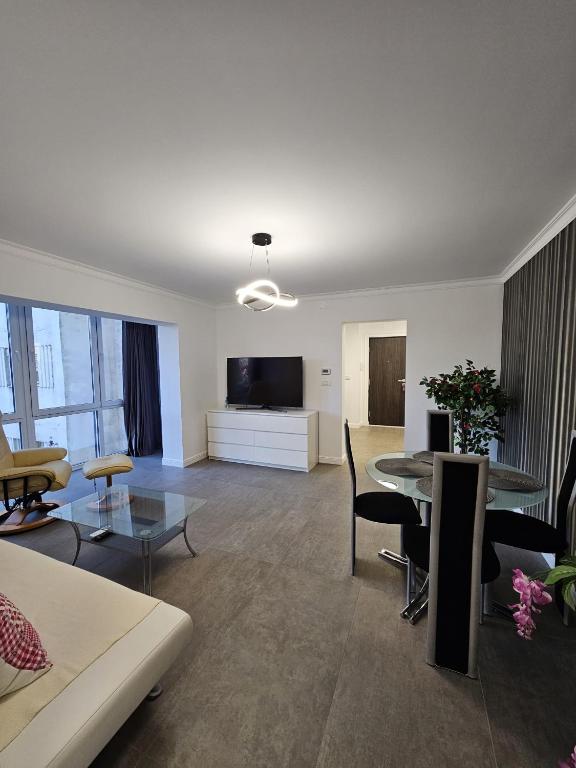 a living room with a table and a tv at Apartament pe malul Mureșului in Arad
