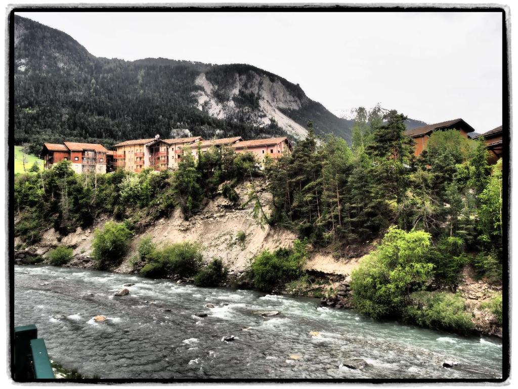 un bâtiment sur une colline à côté d'une rivière dans l'établissement Place du Montagnard à Termignon, à Termignon