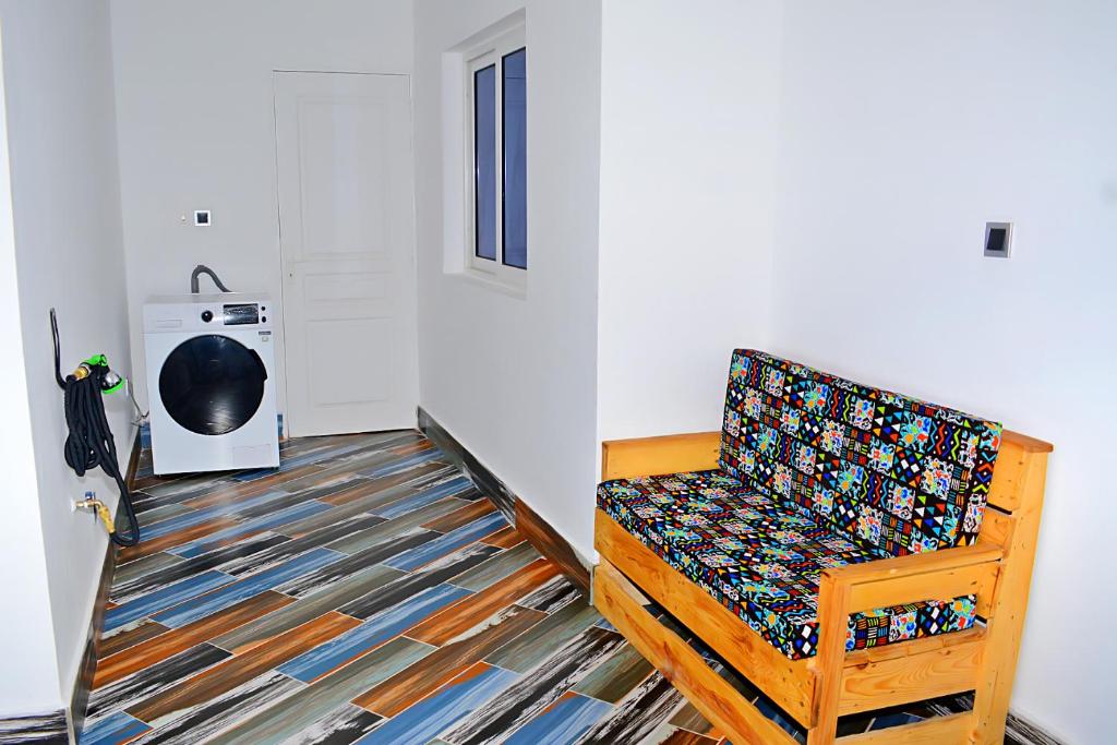 een stoel in een kamer met een kleed bij Appart city in Tokpokondji