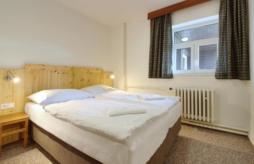 Postel nebo postele na pokoji v ubytování Horský hotel Žižkova bouda