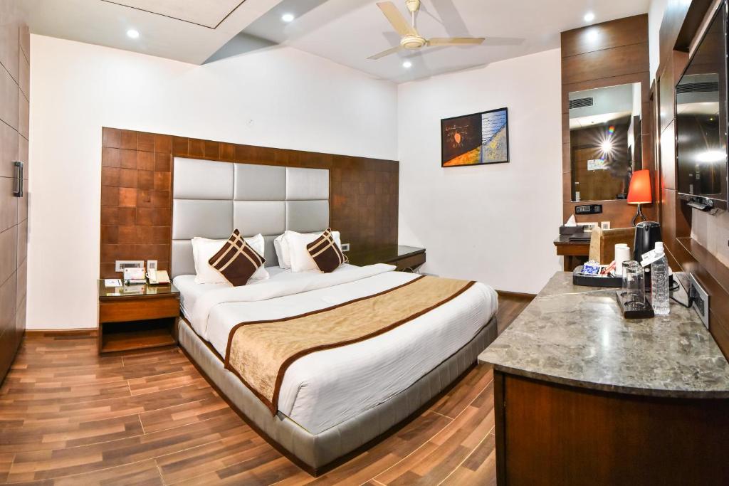 Un dormitorio con una cama grande y un escritorio. en Hotel Sawera Grand Near Golden Temple, en Amritsar