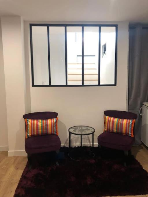 - un salon avec deux chaises et une table en verre dans l'établissement Agréable studio calme et moderne proche Paris et Arena Défense, à Colombes