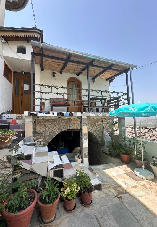 a building with an outdoor patio with an umbrella at Villa Zeko in Gjirokastër