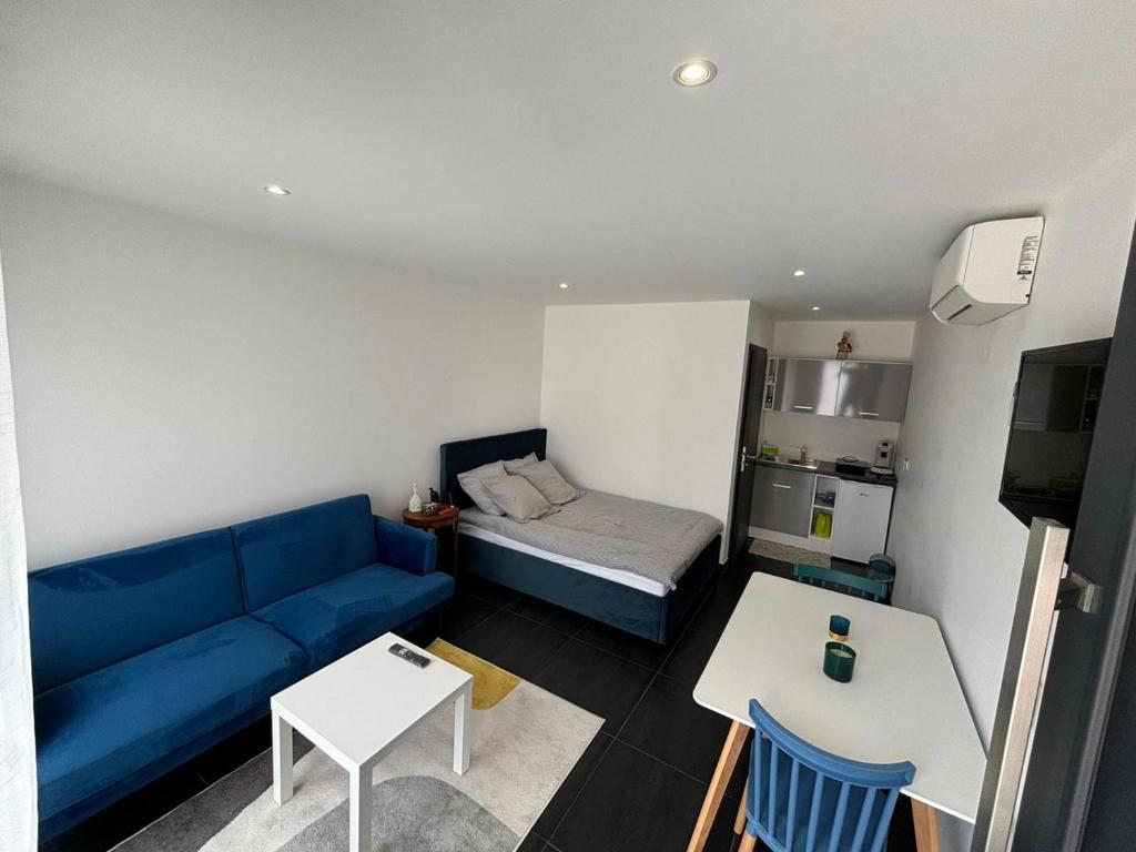a living room with a blue couch and a bed at Studio Bleu in Obernai