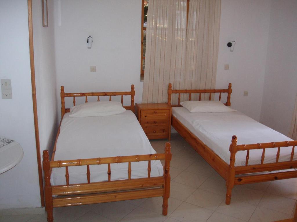 2 camas individuales en una habitación con ventana en The Schoolmistress With The Golden Eyes, studios & rooms, en Mithimna