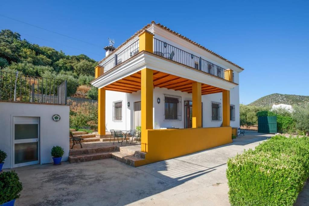 ein gelbes und weißes Haus mit einem Balkon in der Unterkunft Casa Rural El Rincón in Carcabuey
