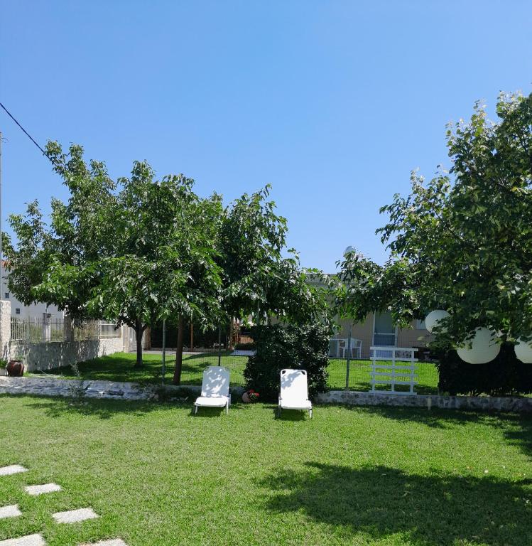 two chairs sitting in the grass in a yard at Vasiliki in Kavála