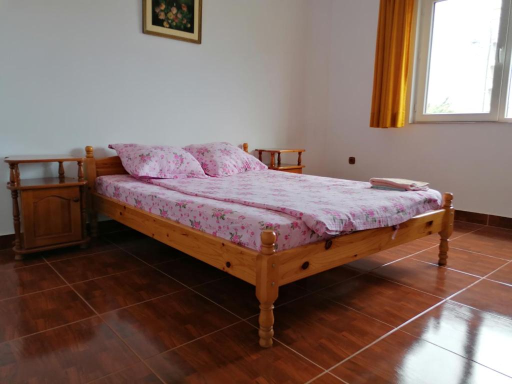 a bedroom with a wooden bed with pink sheets at Casa din Vamă in Vama Veche