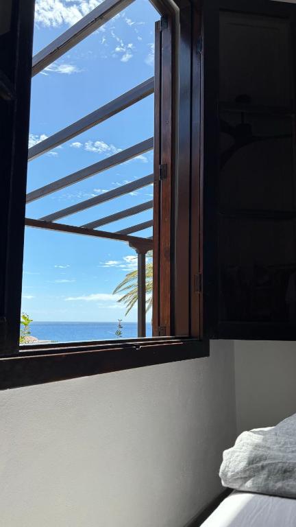 a bedroom window with a view of the ocean at Casa Moni con Vistas al Mar in Playa de Santiago