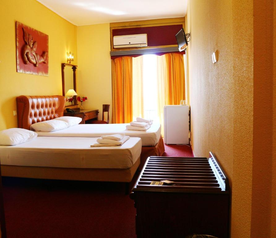 a hotel room with two beds and a window at Galini Palace in Athens