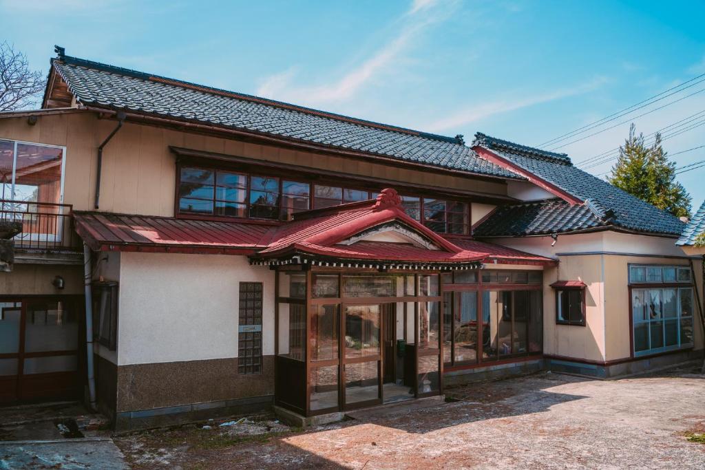 an old house with a red roof at ゲストハウス麓〼-Rokumasu in Yokooka