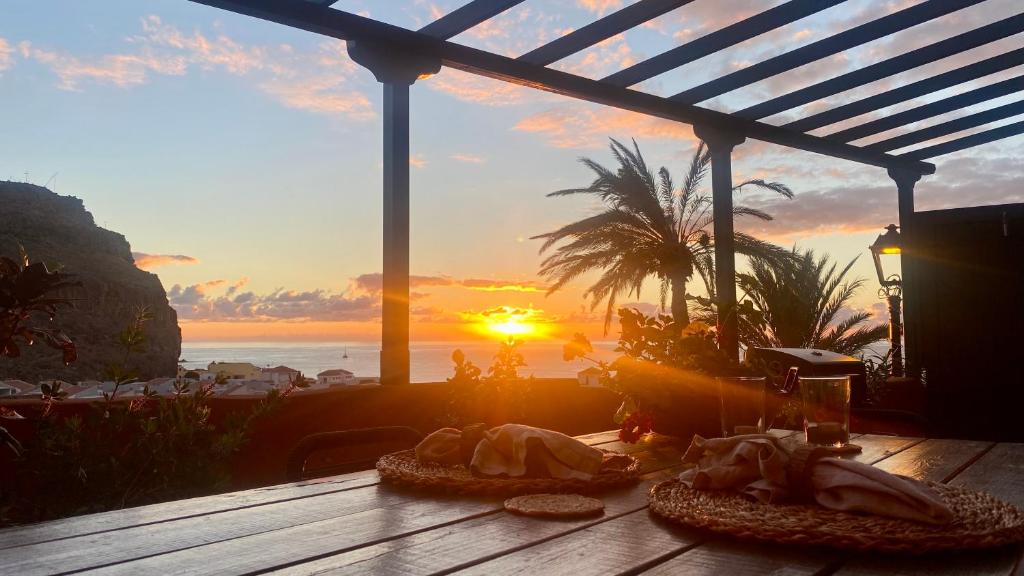 a table with food on it with the sunset in the background at Casa Moni con Vistas al Mar in Playa de Santiago