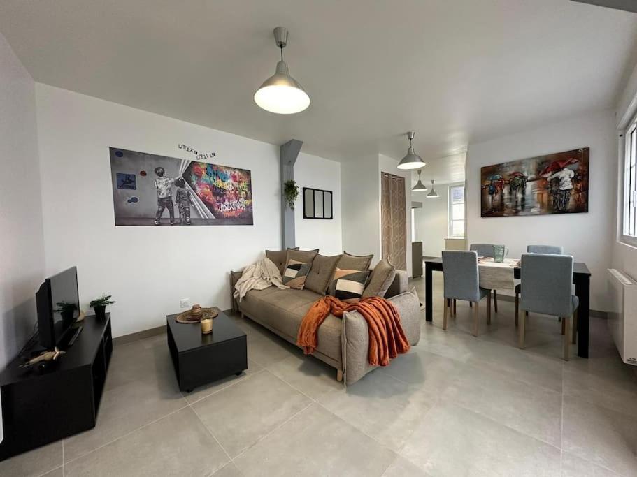 un salon avec un canapé et une salle à manger dans l'établissement URBAN appartement hyper centre, à Bernay