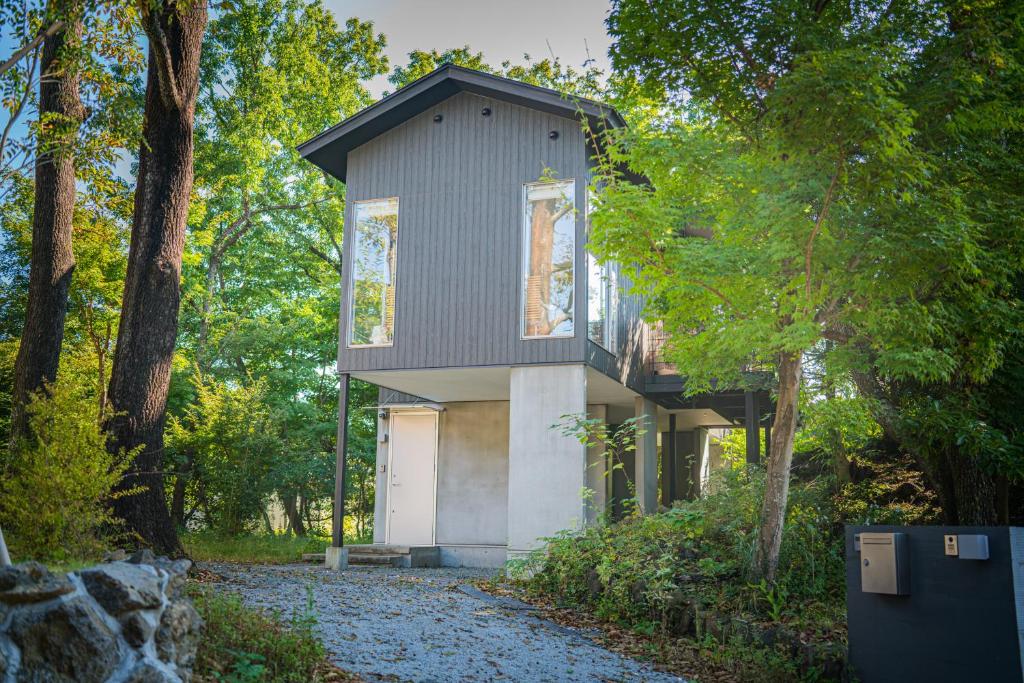 a house in the woods with a garage at Villa By Nature in Yawatano