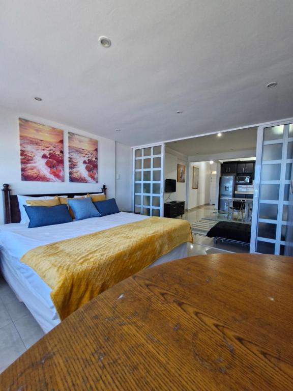a bedroom with a large bed and a living room at Accommodation Front - Beachfront 3 Sleeper with Ocean Views in Durban