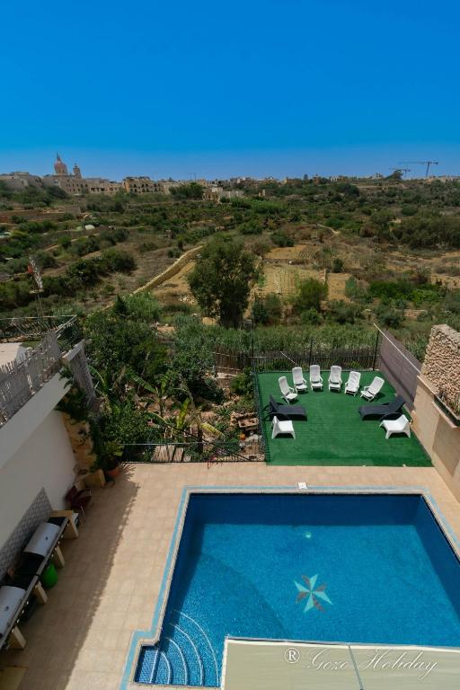an overhead view of a swimming pool with chairs and a table at Dar Tat Tork in Xagħra