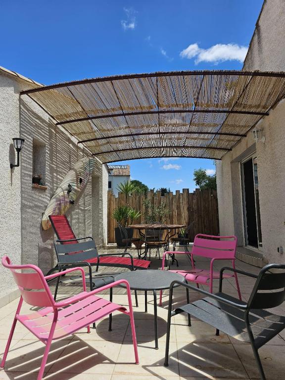 un groupe de chaises et une table sur une terrasse dans l'établissement Maison d Anto, à Sussargues