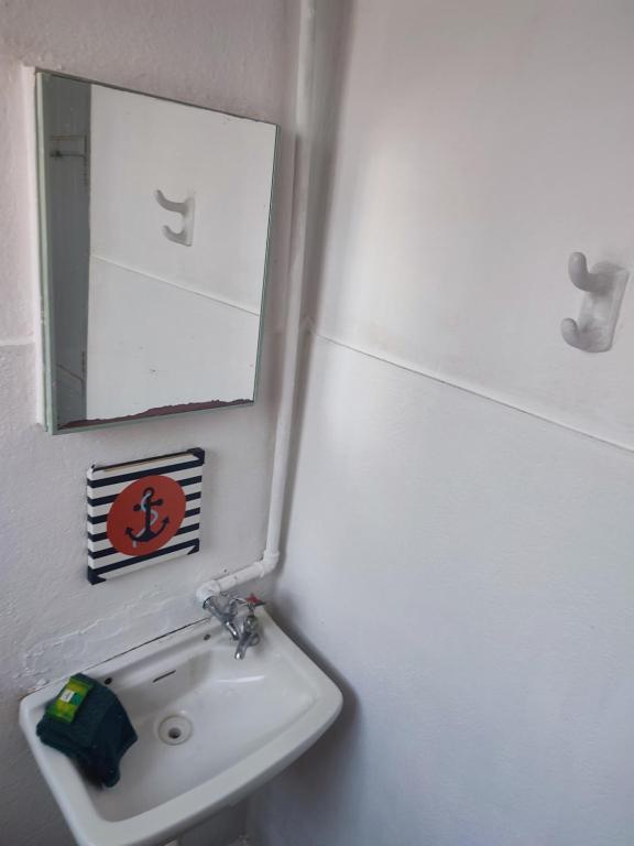 a bathroom with a sink and a mirror at Casa Centenária localizada no calçadão de SLP in São Luiz do Paraitinga