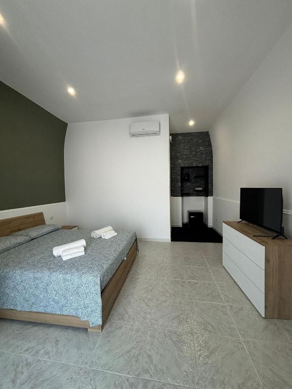 a bedroom with a bed and a flat screen tv at Sempre di Domenica in Santo Spirito