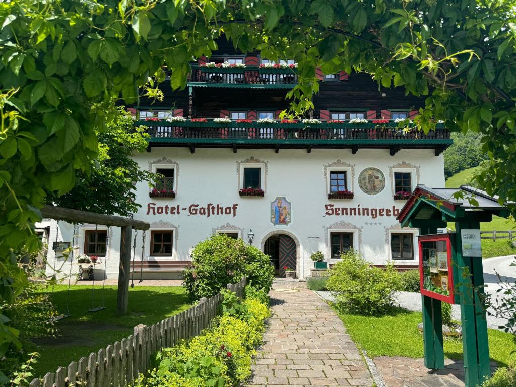 a white building with a balcony on top of it at Hotel Senningerbräu in Bramberg am Wildkogel
