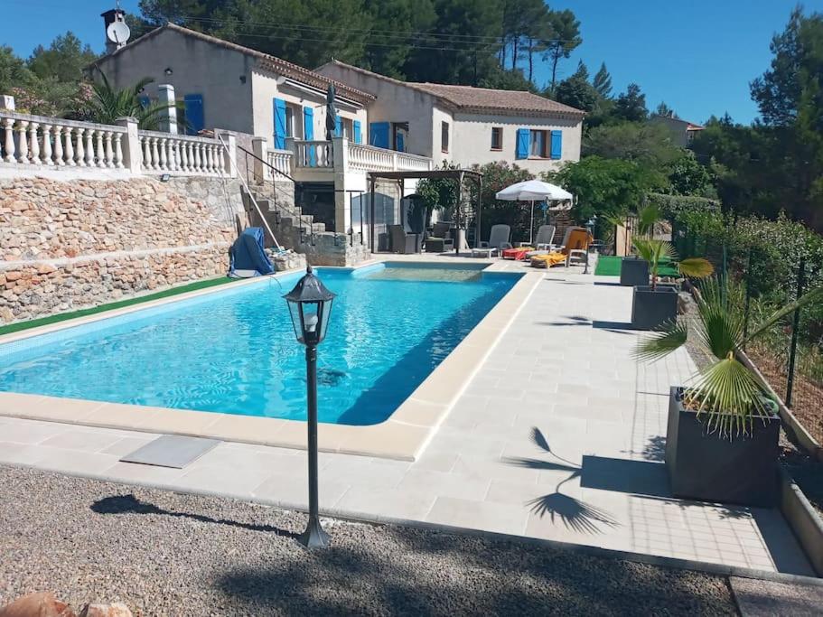 une piscine dans une villa avec une maison dans l'établissement Gîte Le Défends, à Flayosc