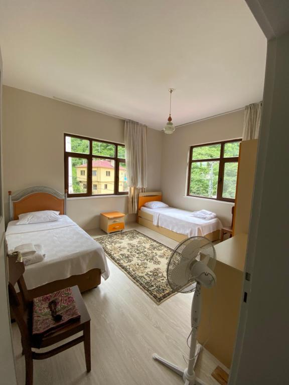 a bedroom with two beds and a fan in it at Yomra İkisu Garden House in Yomra