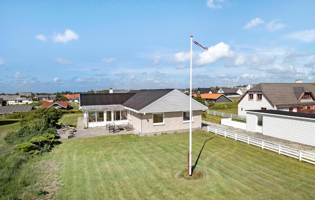 a white house with a flag pole in a yard at Beautiful Home In Thisted With Wifi in Thisted