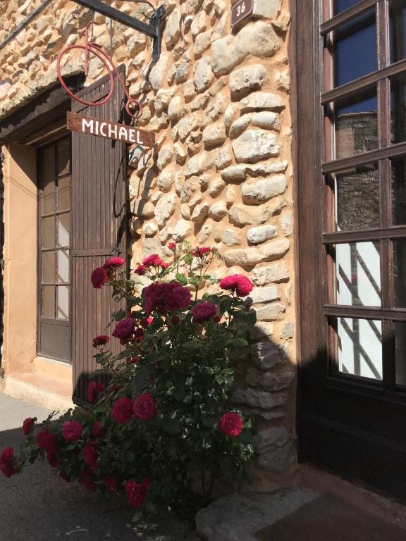 un panier de fleurs sur le côté d'un bâtiment avec des fleurs dans l'établissement maison-michael, à Bédoin