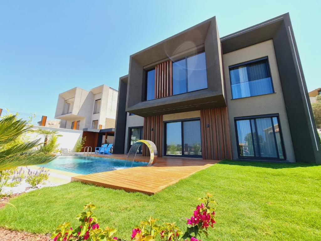 une maison avec une piscine dans la cour dans l'établissement kiralik ultra lux villa, à Kusadası