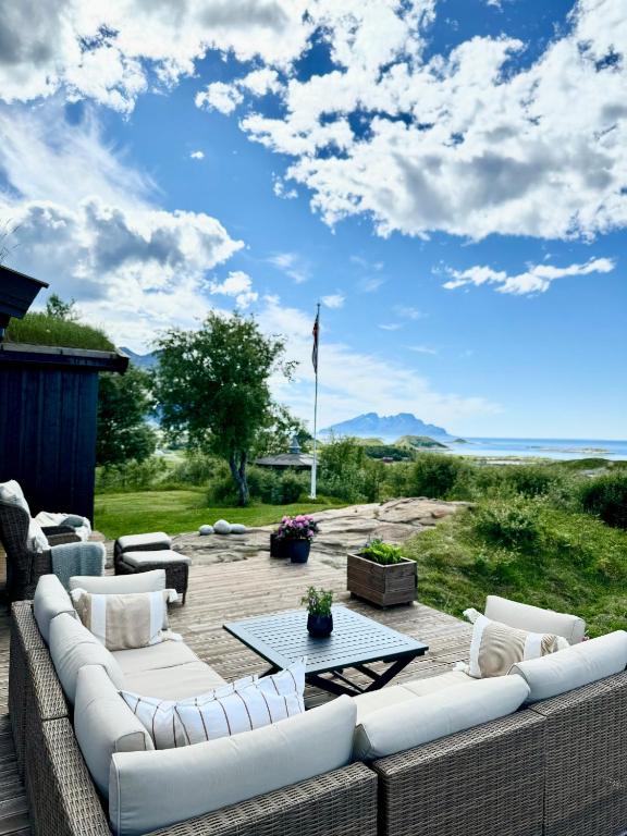 a patio with a couch and a table on a deck at Amazing seaview - Lodge in Bodø