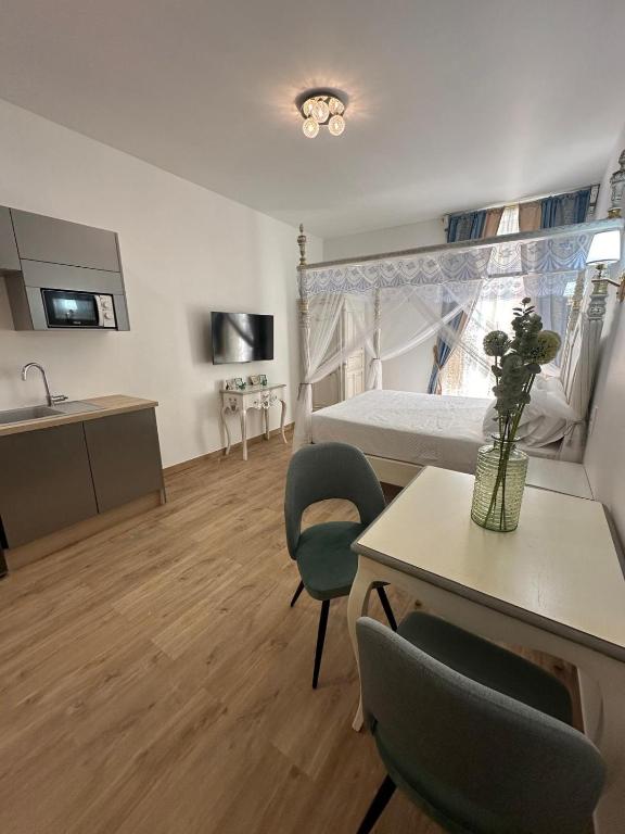 une chambre avec un lit, une table et des chaises dans l'établissement Studio à Baldaquin du Cloitre, à Narbonne