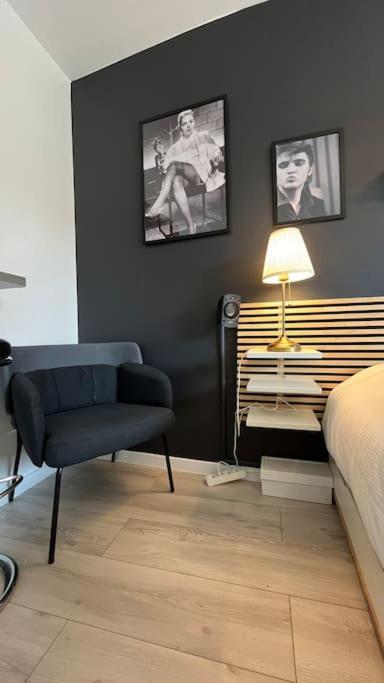 une chambre avec un lit, une chaise et une lampe dans l'établissement Petit Hollywood 2 personnes, à Strasbourg