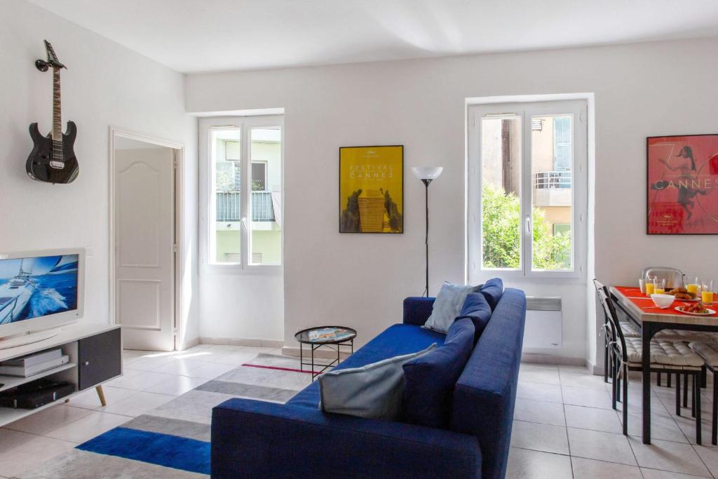 un salon avec un canapé bleu et une table dans l'établissement Appartement Gambetta - Welkeys, à Nice