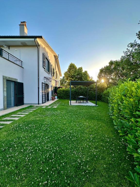 a grassy yard with a gazebo in front of a building at La Sovrana dei Cimini in Bagnaia