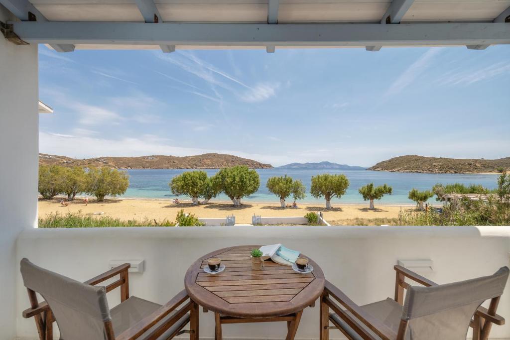 a table and chairs on a balcony with a view of the beach at Galazio Seaside Apartments in Livadakia