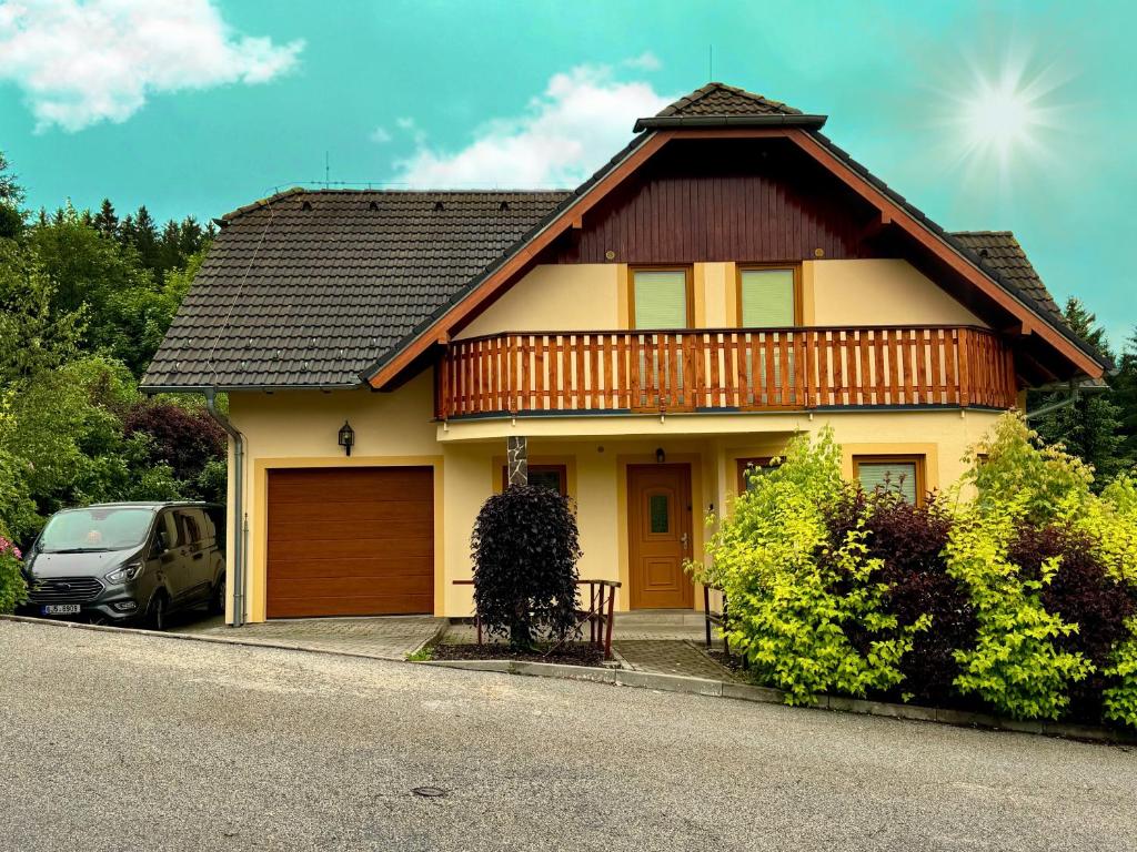 dom z drewnianym dachem i samochód zaparkowany przed budynkiem w obiekcie Villa Slupečná w mieście Lipno nad Vltavou