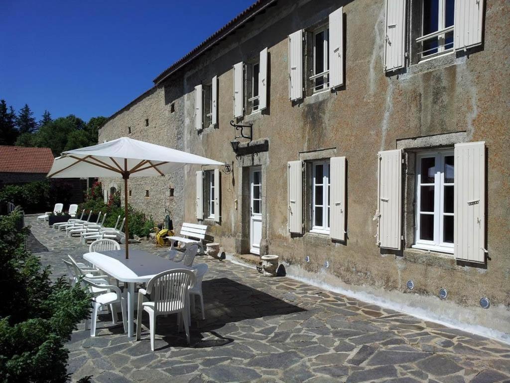 - une table avec des chaises et un parasol à côté d'un bâtiment dans l'établissement Domaine Sainte Germaine chambre d'hôte Stevenson, à Luc