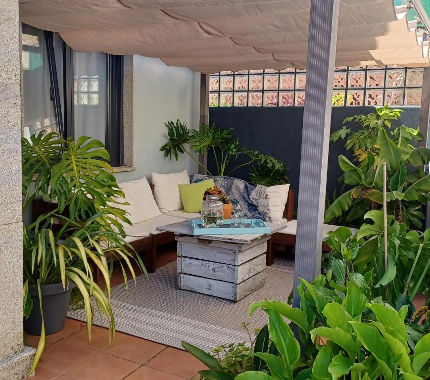 a patio with a couch and a table at Piso a pie de playa con terraza exclusiva in Moaña