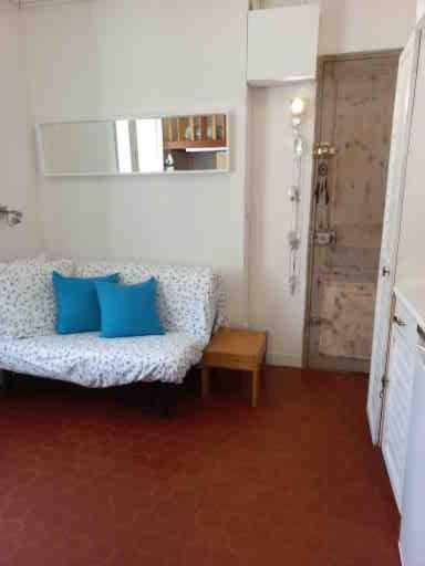 un salon avec un canapé avec des coussins bleus dans l'établissement les pieds dans l'eau, à La Seyne-sur-Mer