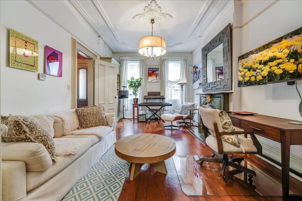 un soggiorno con un divano e un tavolo di Artist Residence 3 Bedroom Brownstone a Hoboken