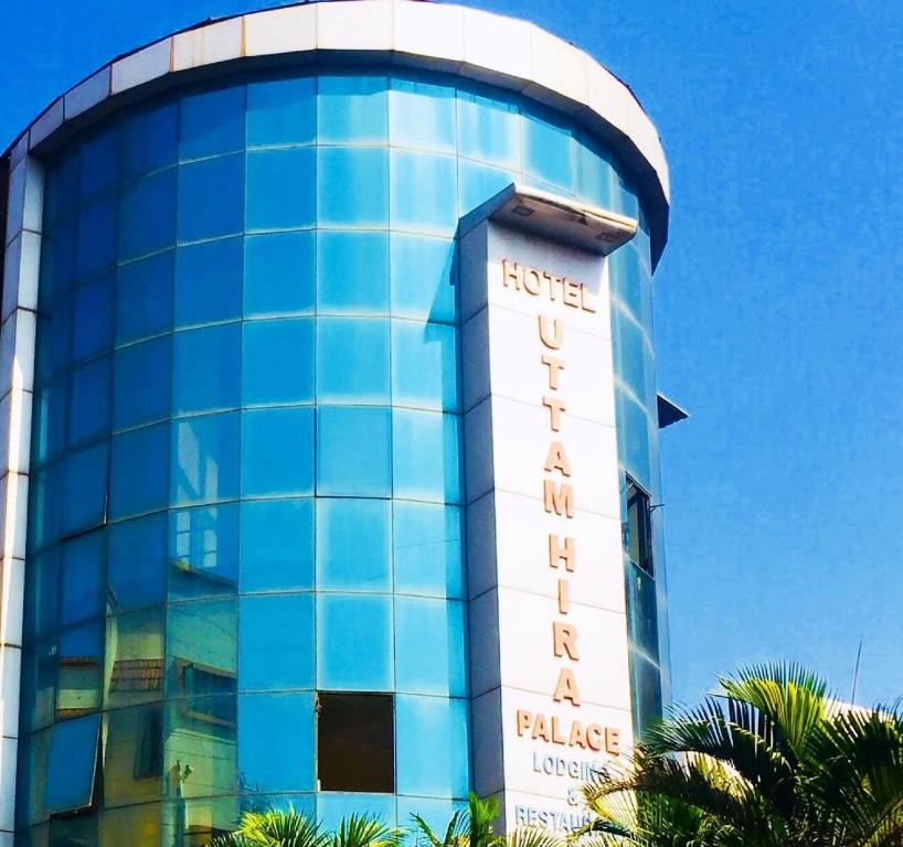 a building with a sign on the side of it at Hotel New Uttam Hira Palace in Nashik