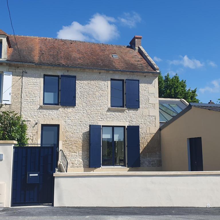 une maison avec volets bleus et garage dans l'établissement Maison Almati près de l'île enchantée, à Fleury-sur-Orne