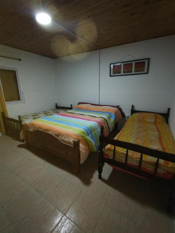 two beds sitting in a room with at El Campanario in Malargüe